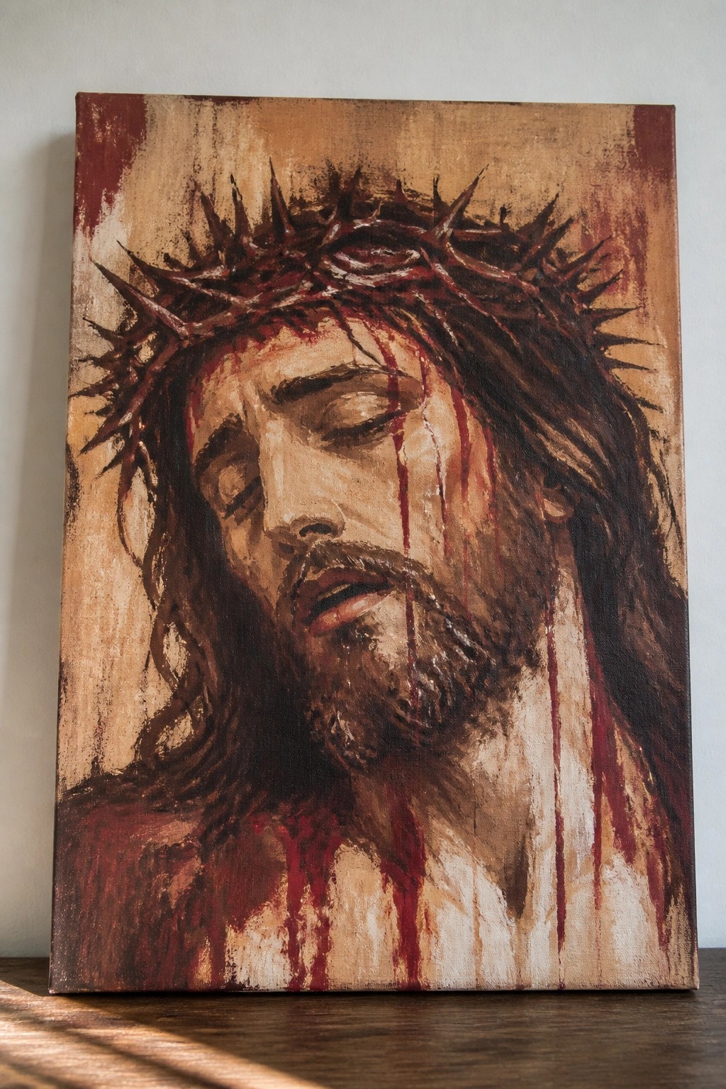 Oil painting of Jesus with crown of thorns, blood streaking his closed-eyed face.