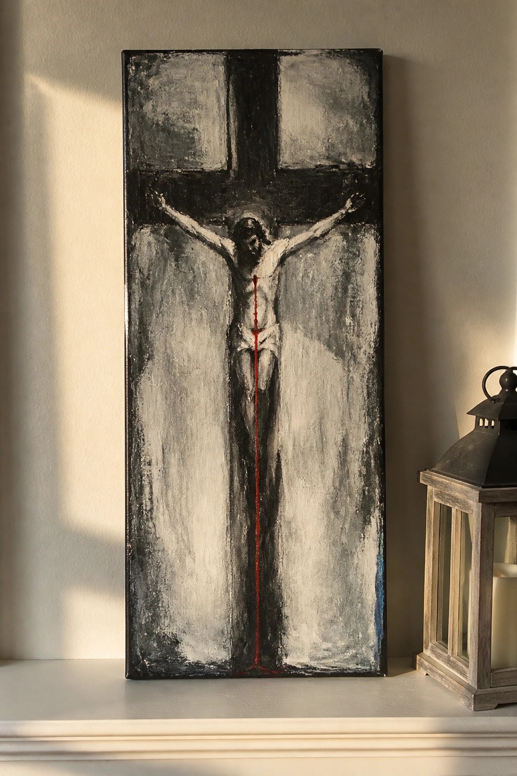 Abstract crucifixion painting in black and white with red blood streak beside wooden lantern