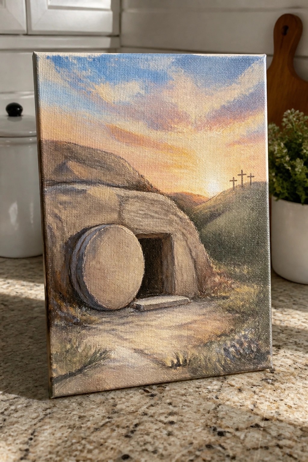 Canvas painting of empty tomb with rolled stone and three crosses under vibrant sunset sky