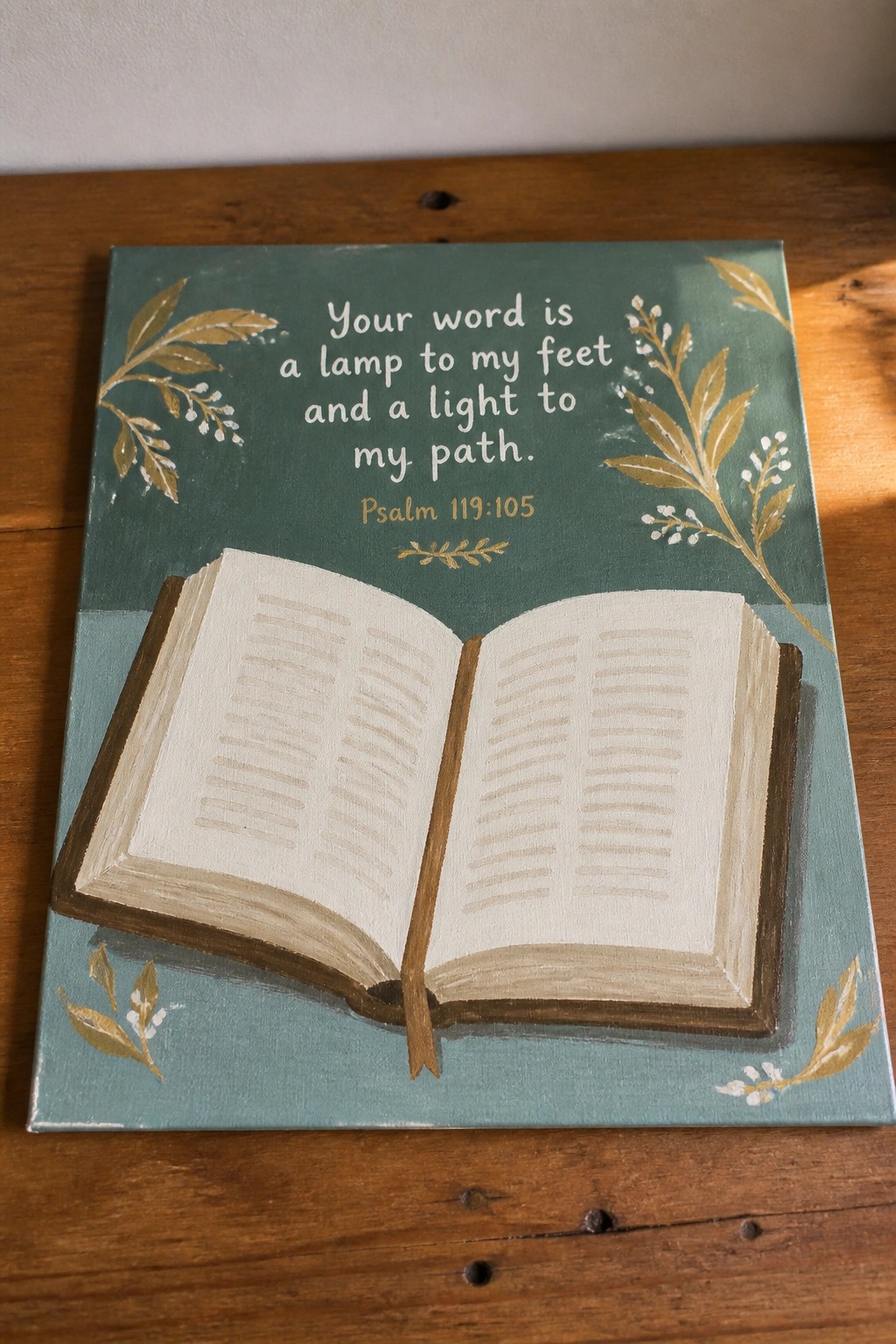 Teal canvas painting of open book with gold leaves and Psalm 119:105 verse.
