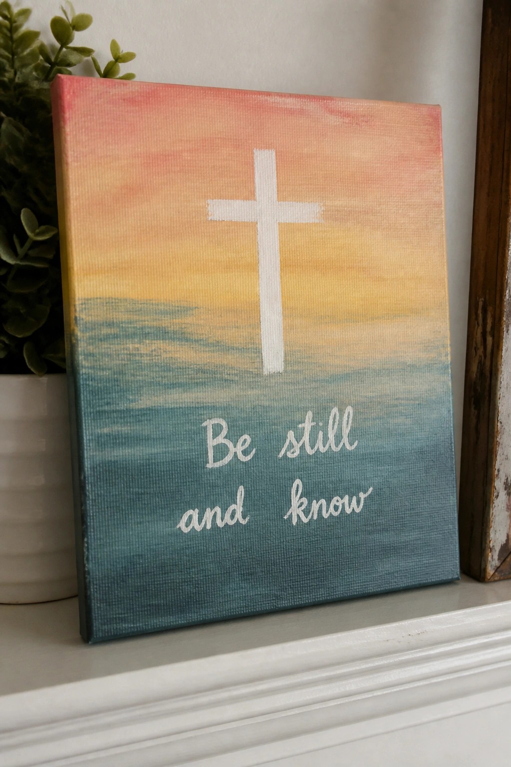 Canvas with white cross on pink-yellow-blue sunset seascape and 