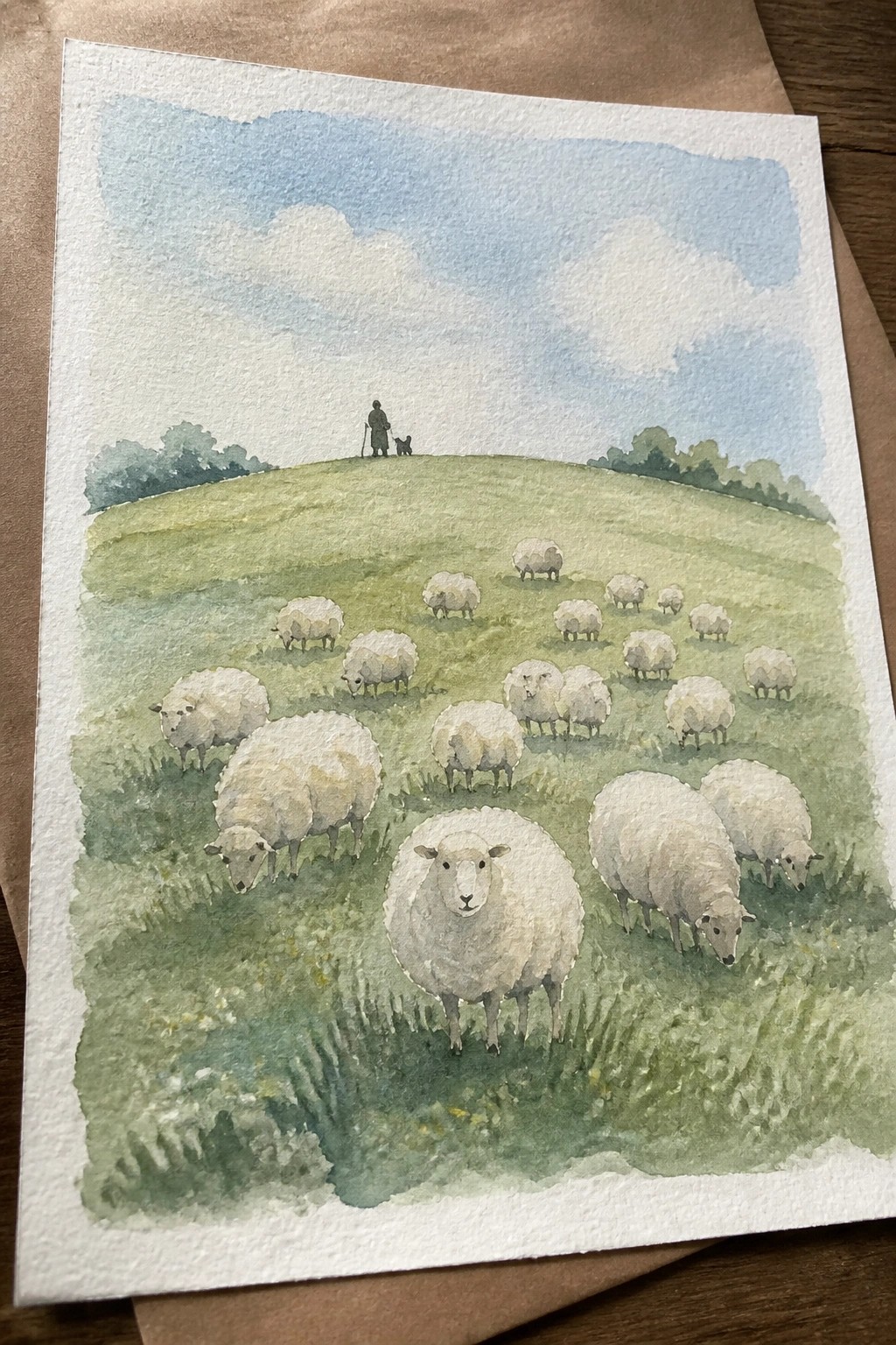 Watercolor of white sheep grazing on green hills, shepherd with dog on distant ridge under blue sky.