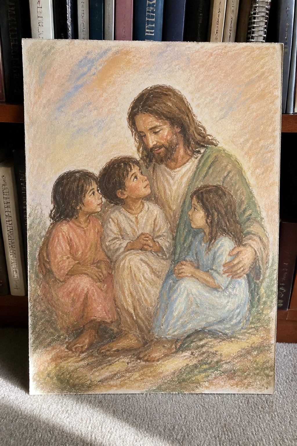 Jesus in green robe with three barefoot children on ground, pastel style, books behind