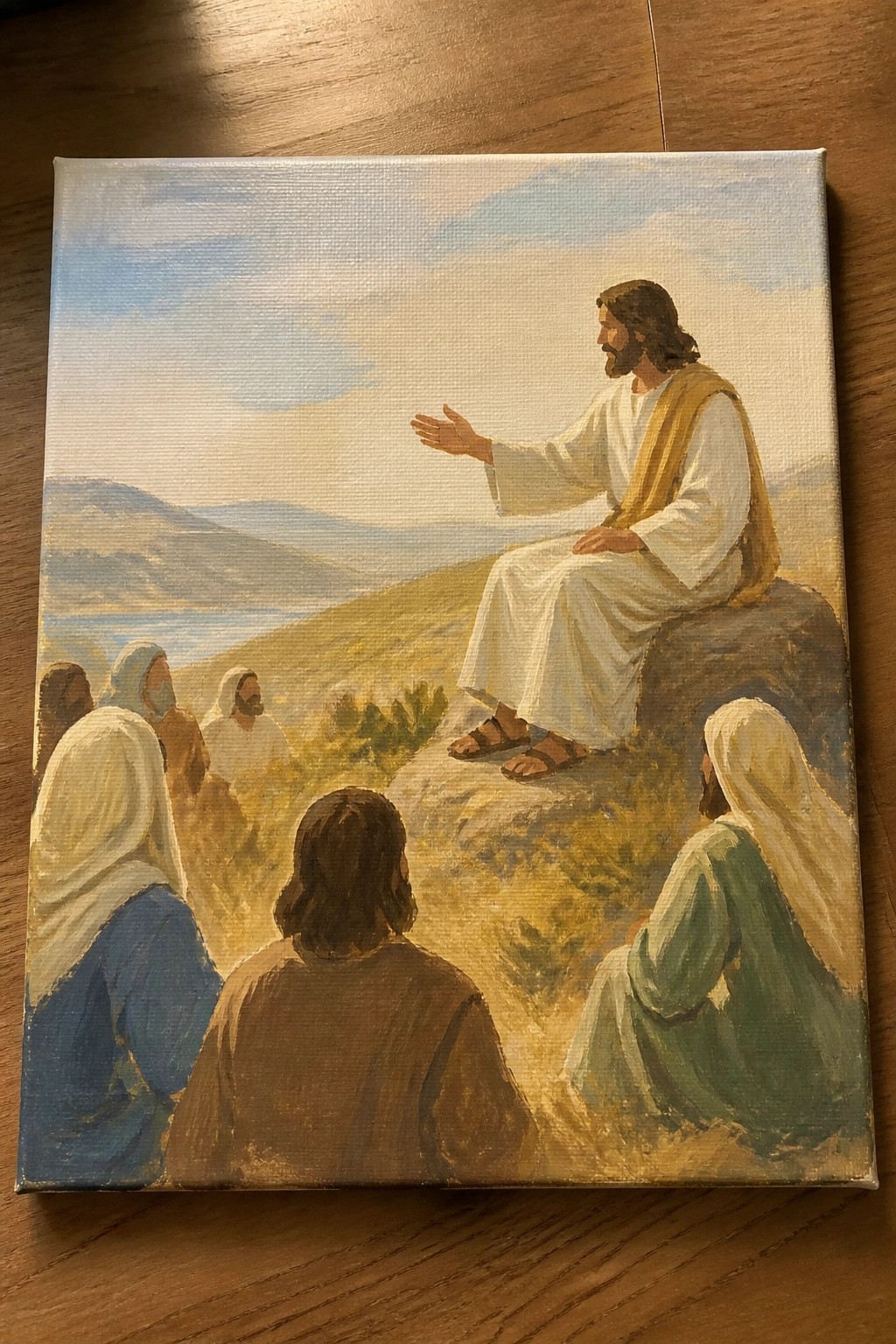 Jesus in white robe gestures from rock to robed listeners on sunny hillside