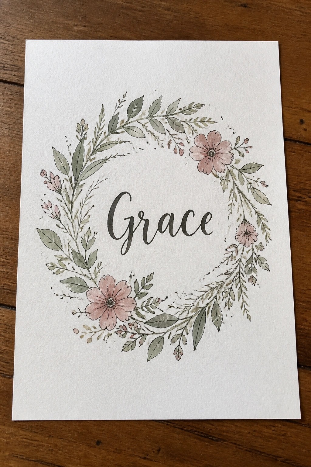 Watercolor wreath of pink flowers and green leaves with cursive name Grace