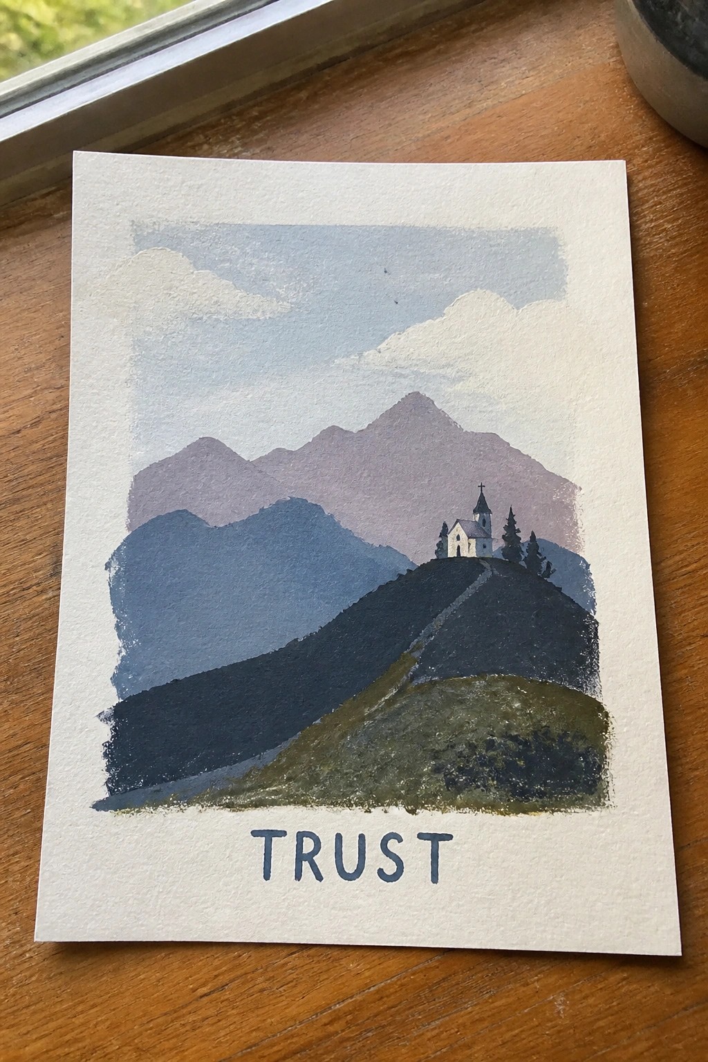 Watercolor mountains with church on hill, path, and TRUST text below