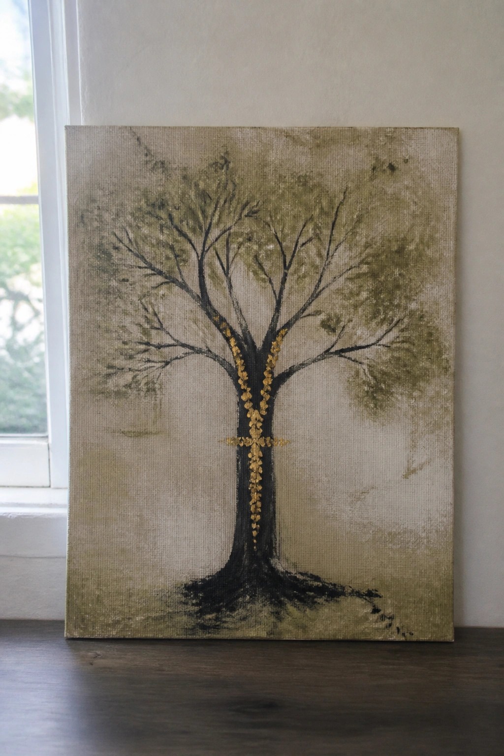 Tree painting with black trunk and golden leaves forming cross on beige canvas