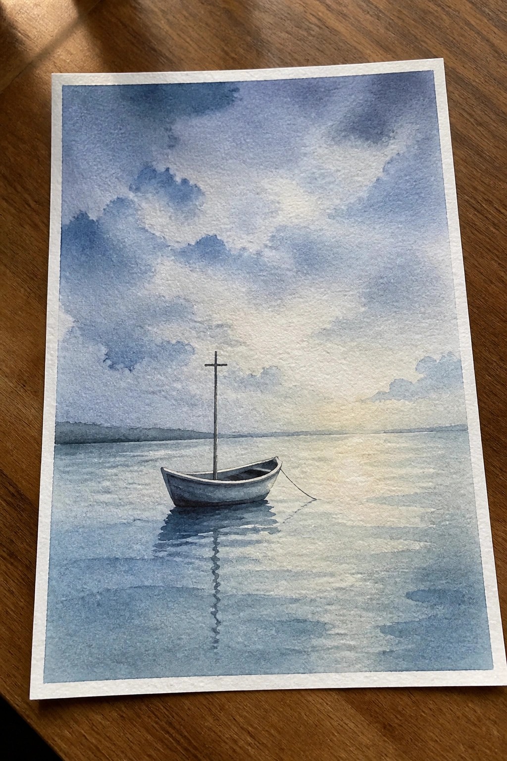 Watercolor of small boat with mast on calm reflective blue water under cloudy sky