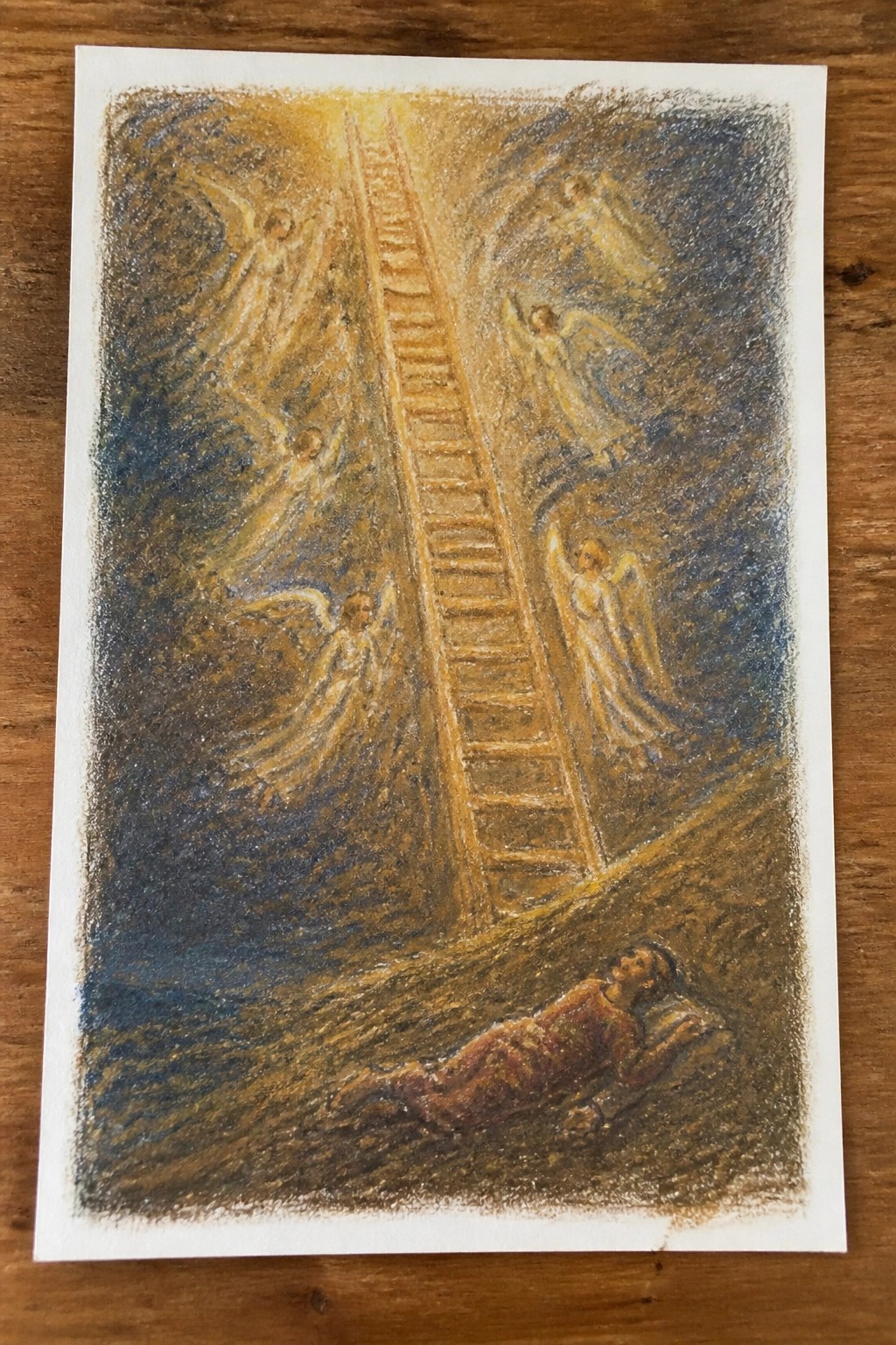 Reclining man dreams of angels on glowing ladder amid starry blue and gold.