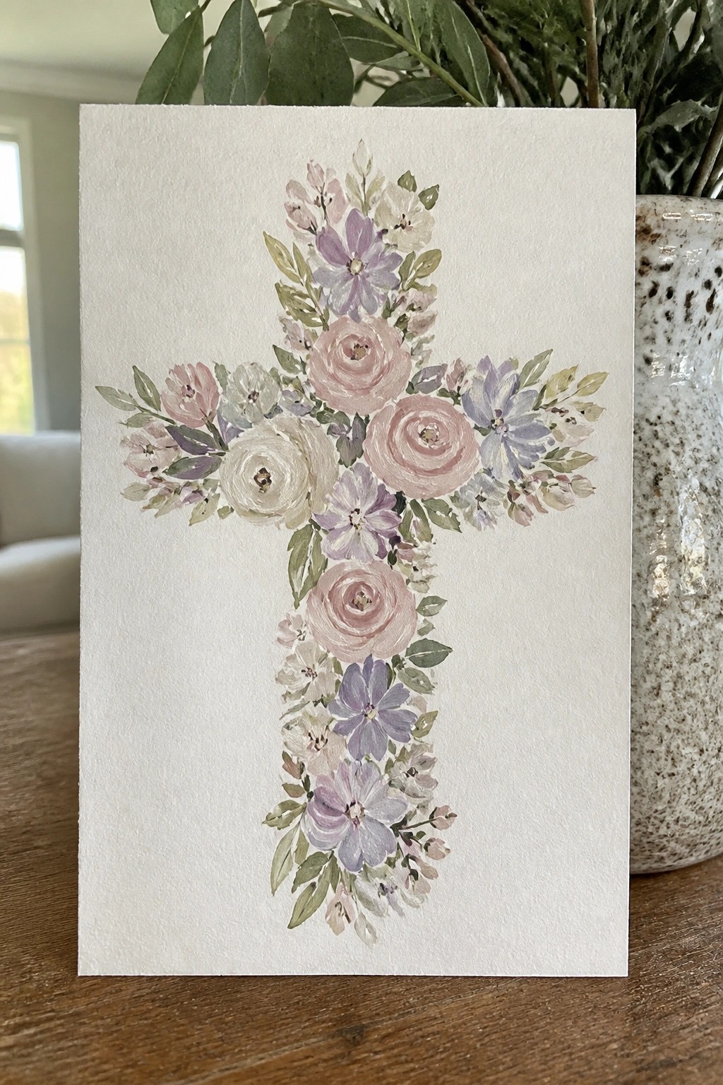 Watercolor floral cross with pink roses, lavender blooms, and green leaves on paper