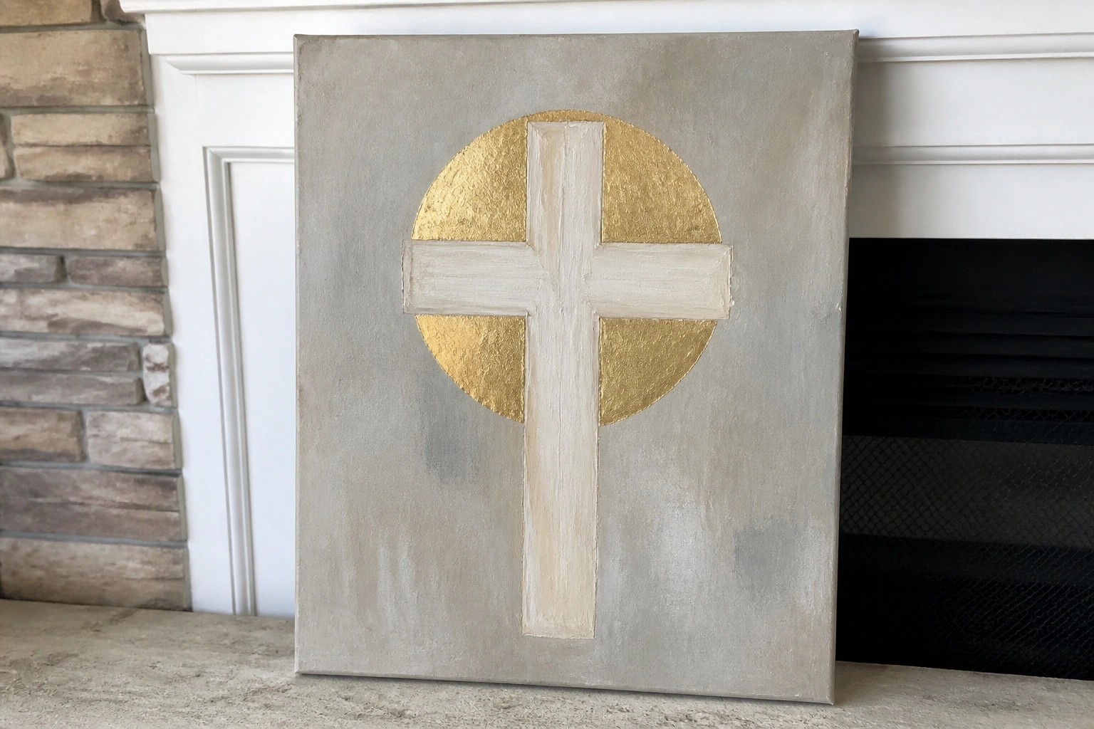 Textured gray canvas with white cross in gold circle on white mantel.