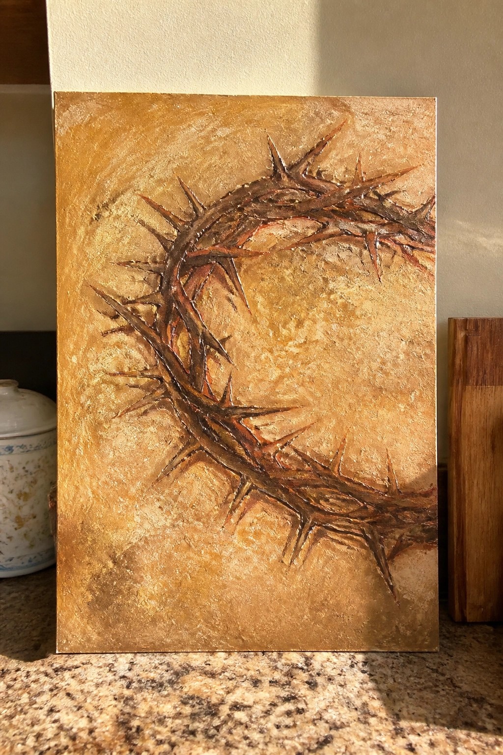 Thickly textured painting of a thorny crown on mottled golden background.
