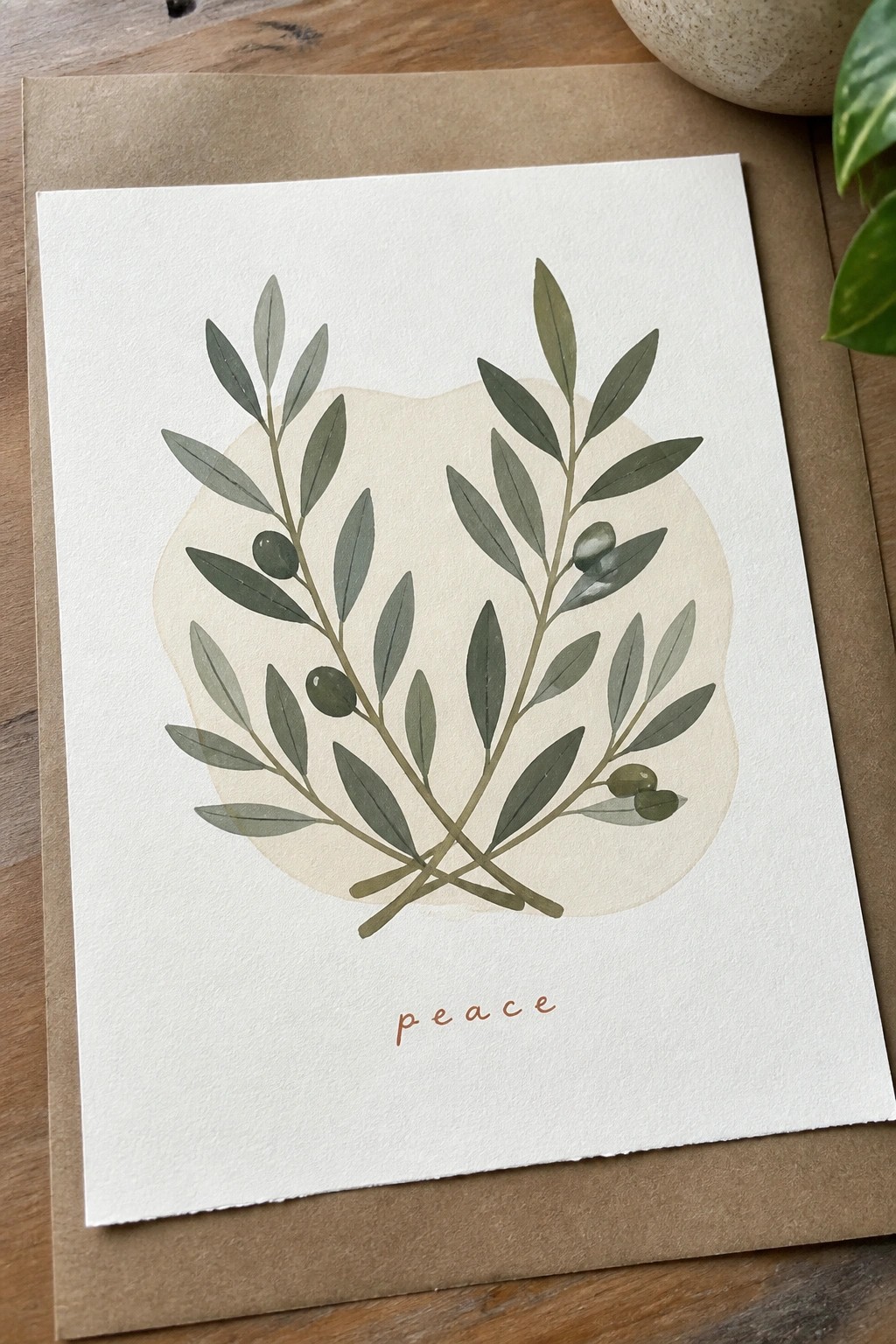 Watercolor olive branches on white card with cursive peace text below