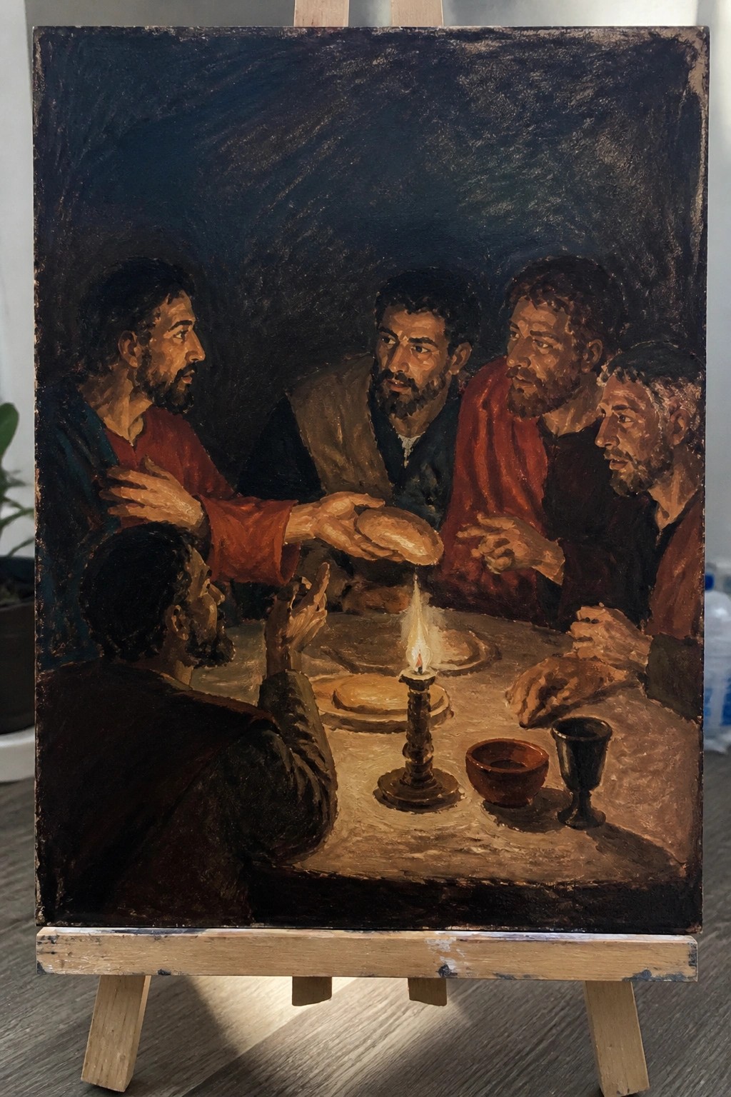 Bearded men in colorful robes at a candlelit table breaking bread in a dark room.
