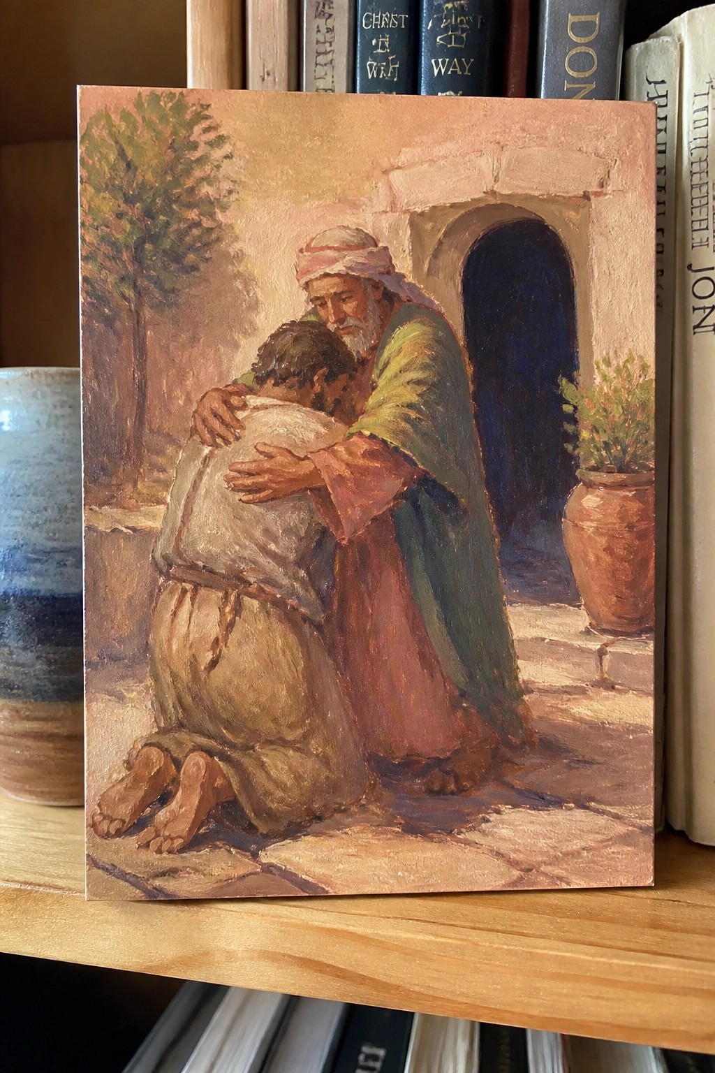 Oil painting of bearded man in robes embracing kneeling figure by stone archway.