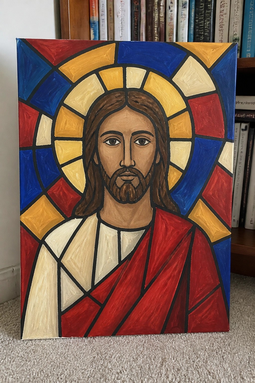 Stained-glass style portrait of Jesus with brown hair, beard, and red robe