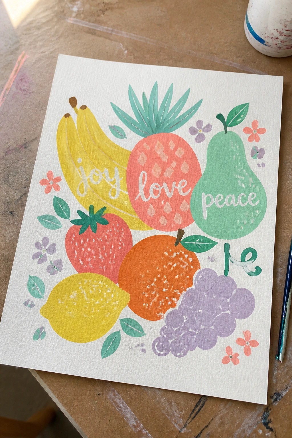 Vibrant watercolor fruits with joy, love, peace text amid flowers and leaves