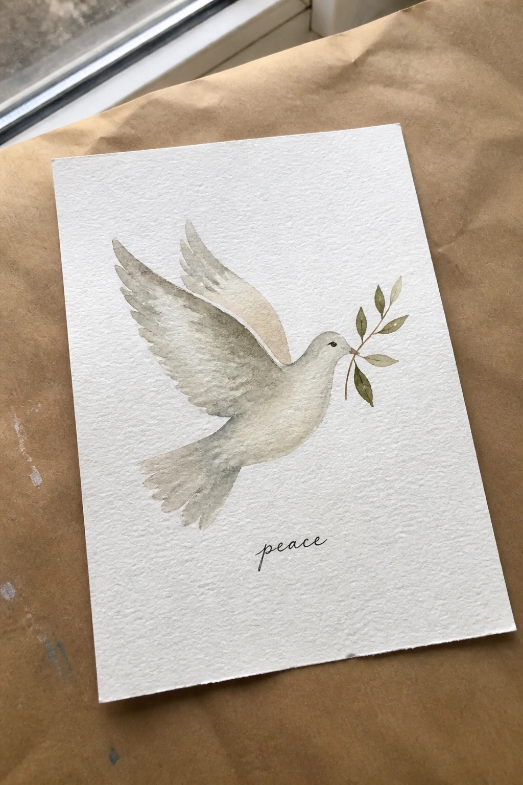 Watercolor dove in flight with olive branch and cursive 