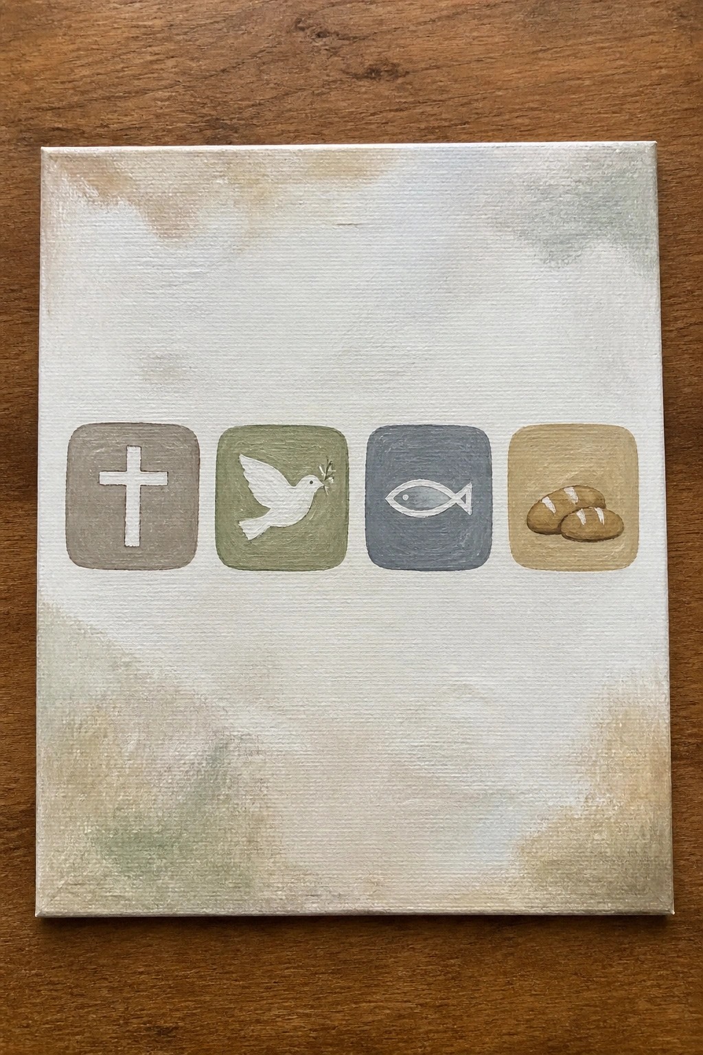 Canvas painting with cross, dove, fish, and bread icons in colored squares.
