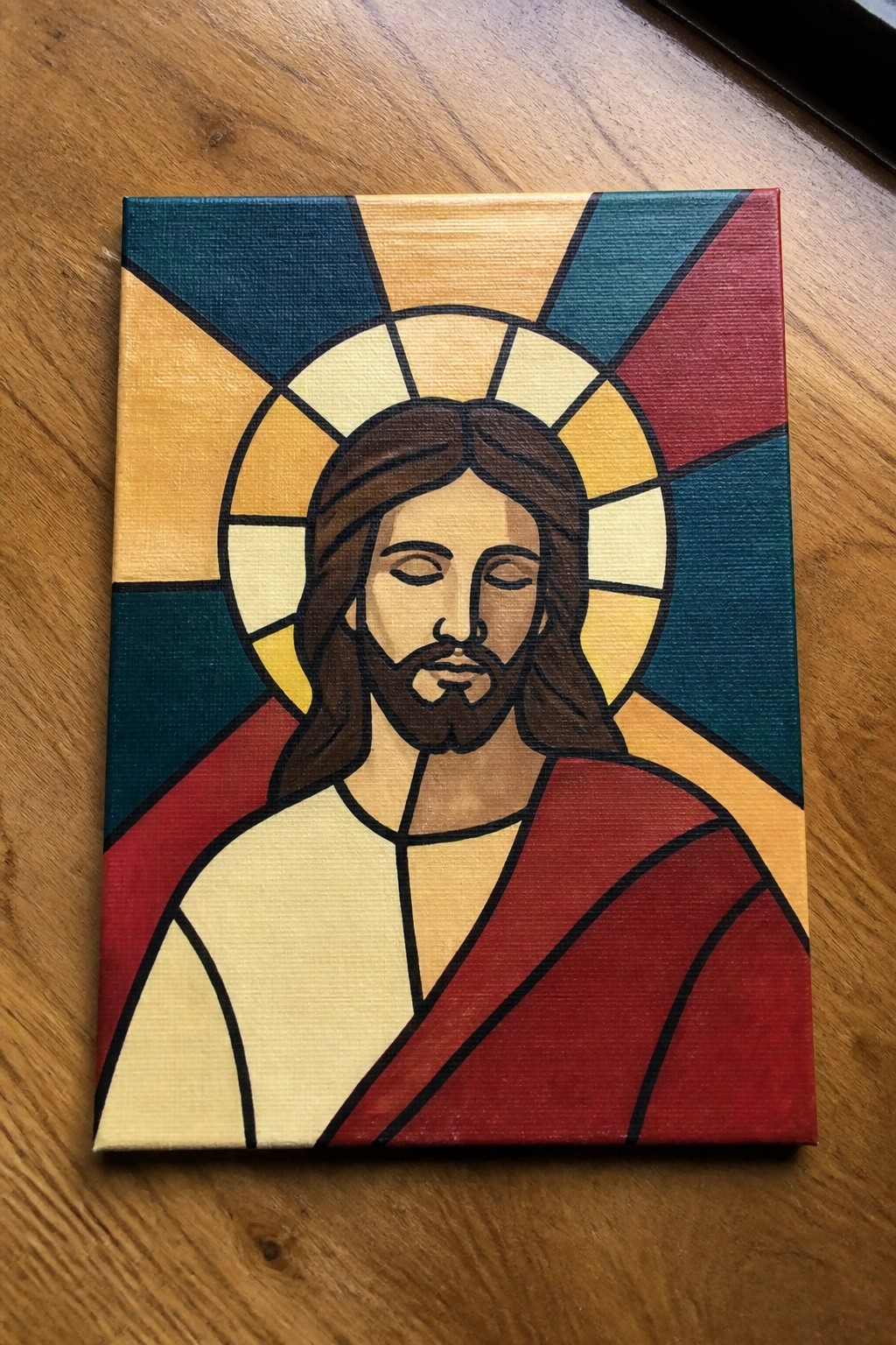 Stylized portrait of Jesus with halo against colorful geometric rays in red and teal.