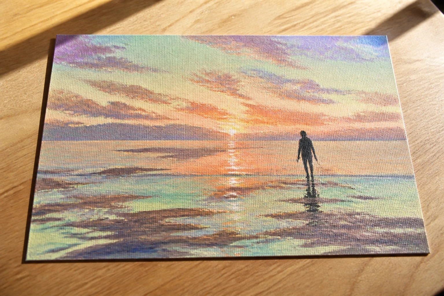 Vibrant canvas painting of silhouetted figure walking toward orange sunset on beach