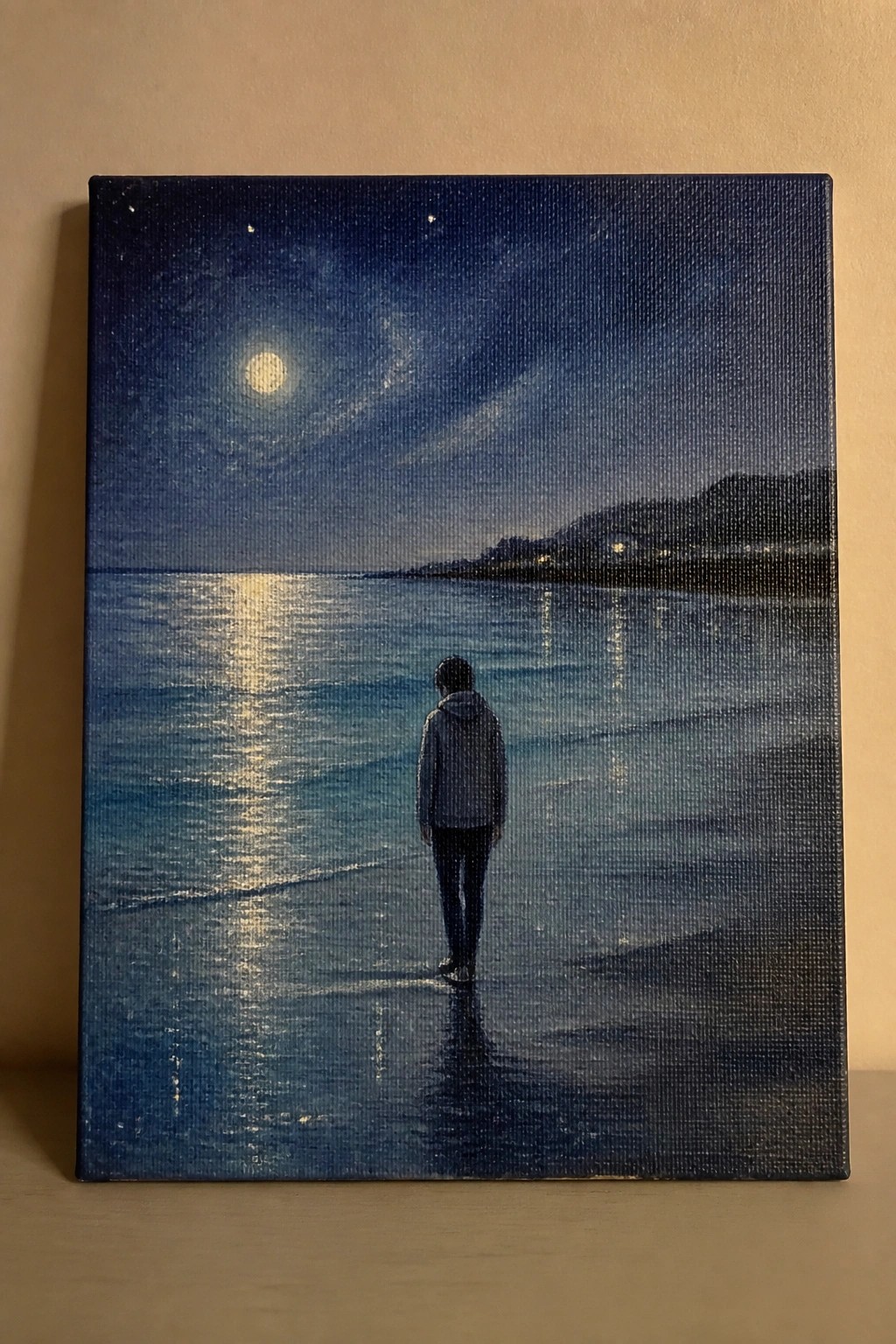 Canvas painting of person in hoodie walking on moonlit beach under full moon