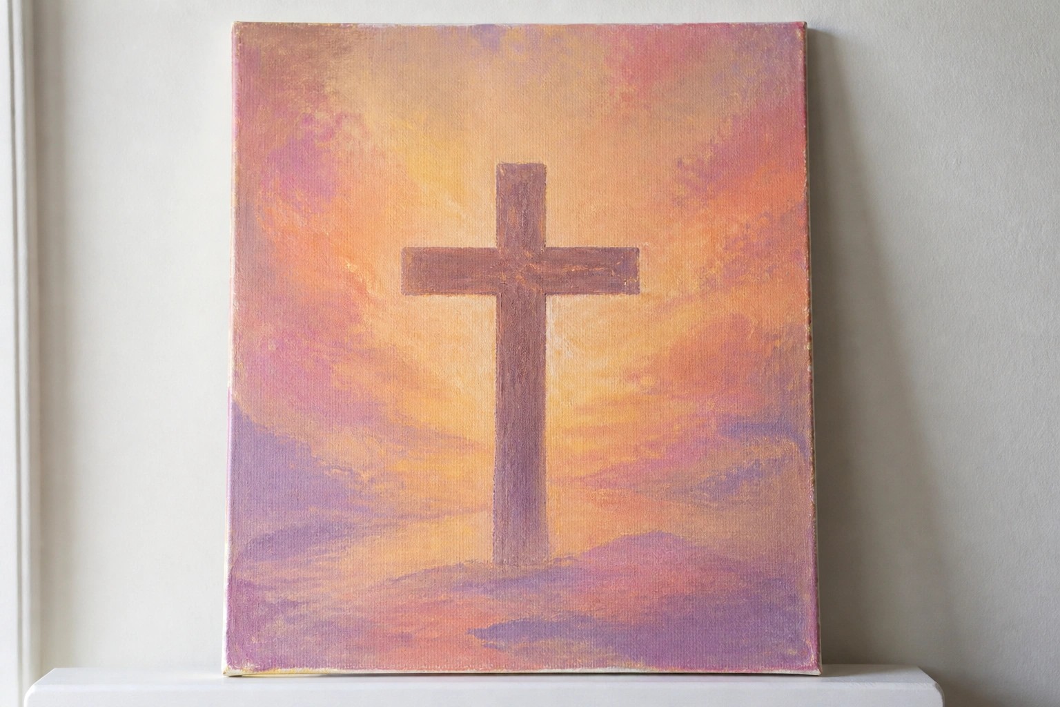Purple cross centered on canvas amid vibrant pink orange sunset over purple hills