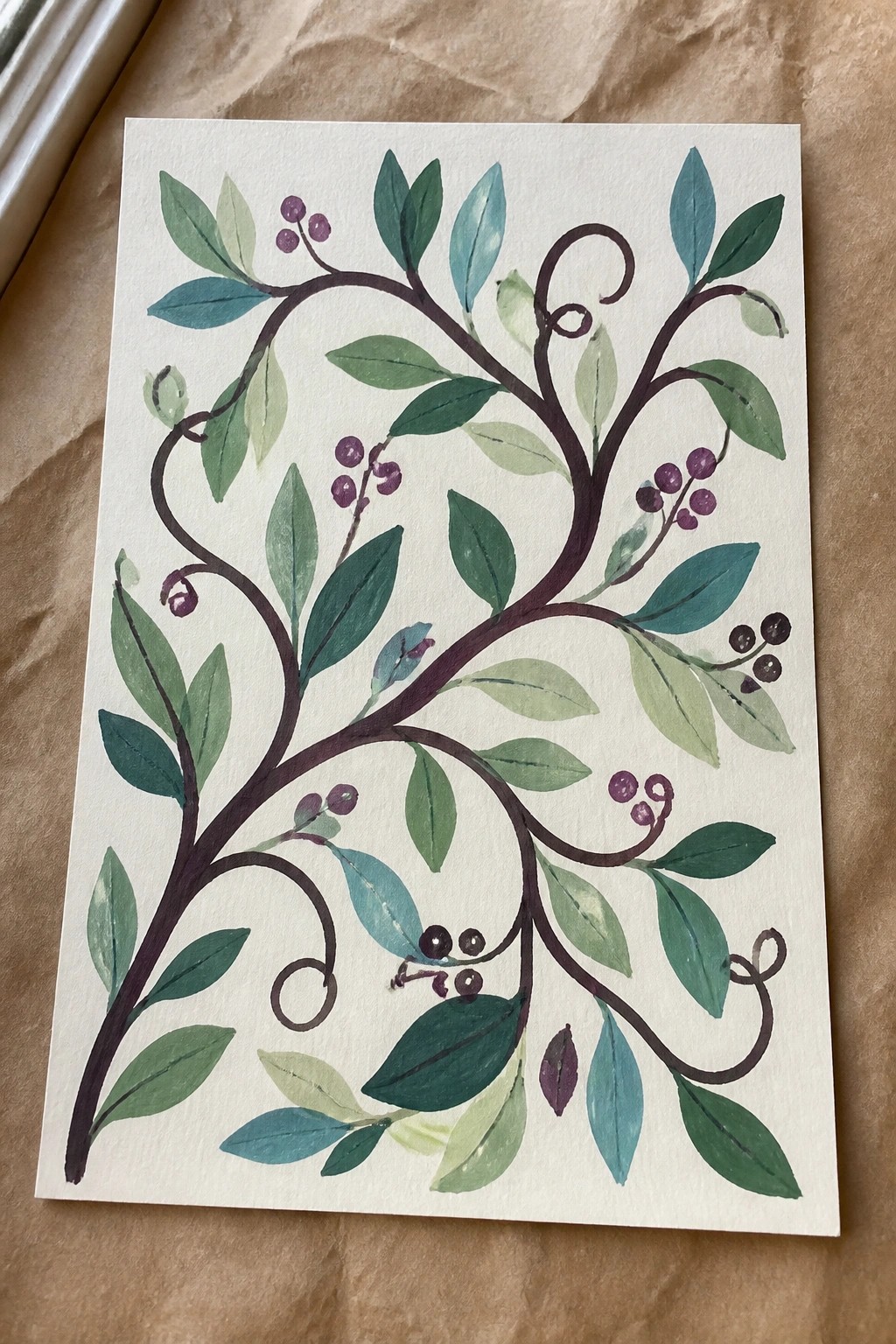 Watercolor of curling branches with green-blue leaves and purple berry clusters.