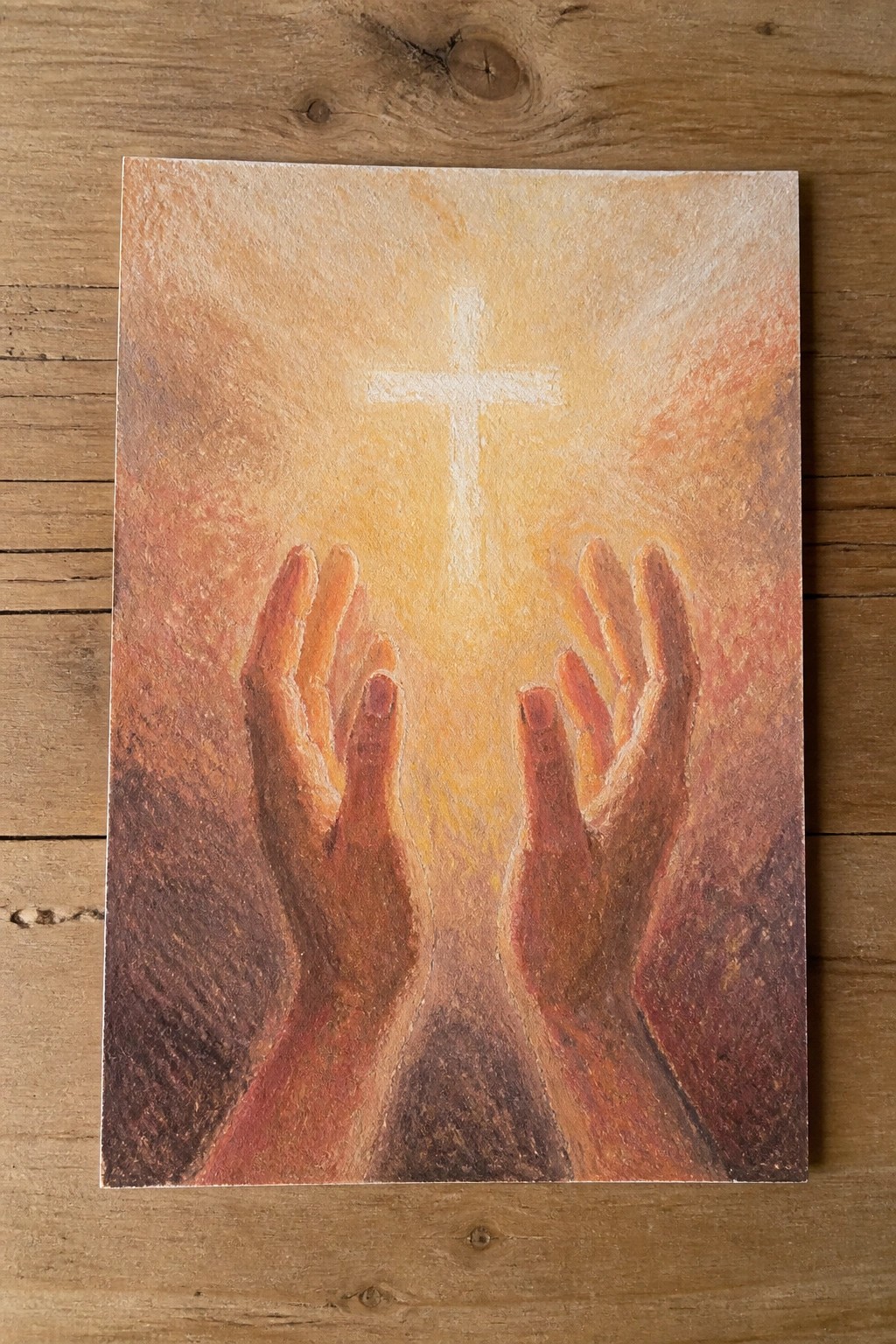 Two hands reaching upward toward a glowing white cross in warm orange light
