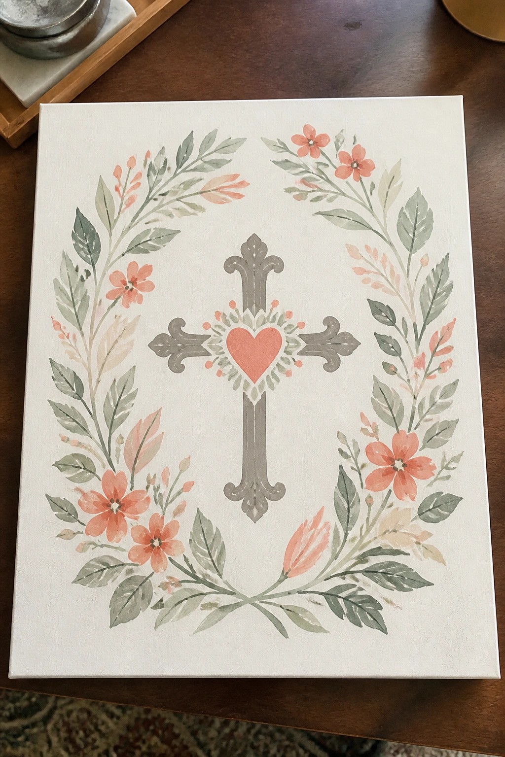 Watercolor floral wreath encircling ornate gray cross with red heart on white canvas