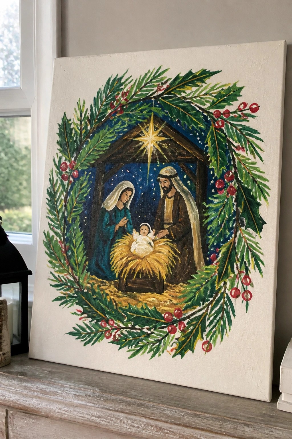 Canvas painting of nativity scene encircled by green wreath with red berries and shining star.