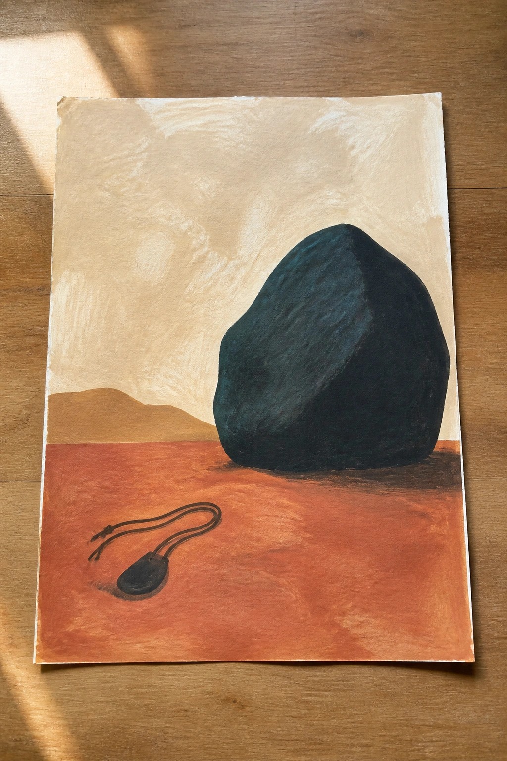 Large dark boulder on red desert with small sling, distant hills, and beige sky.
