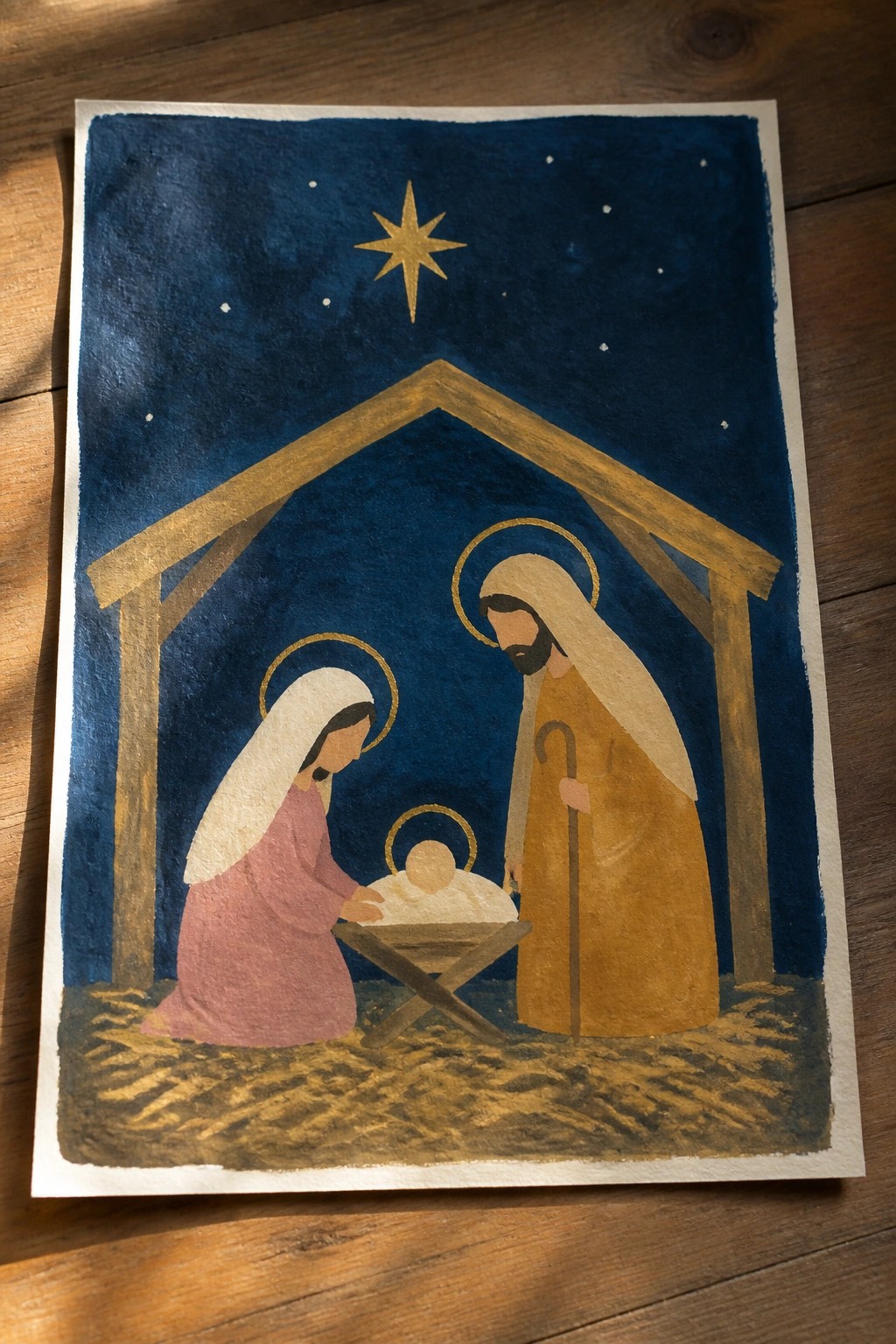 Watercolor nativity with Mary in pink, Joseph in yellow, halos, manger under golden star.