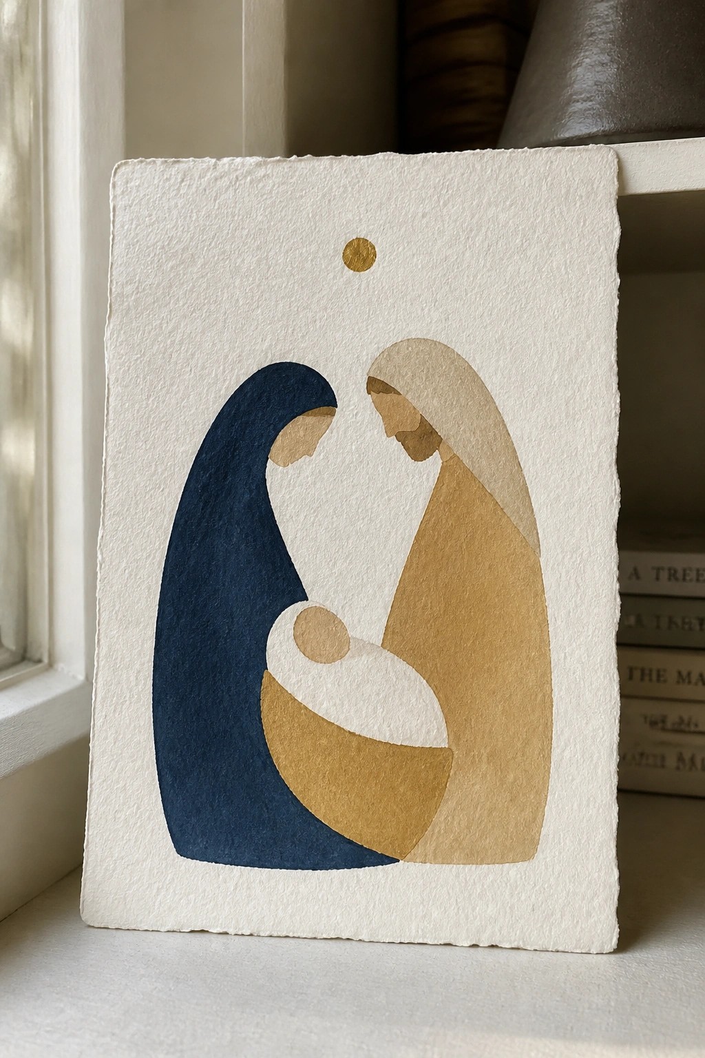 Minimalist watercolor of Mary in blue, Joseph in beige, and swaddled infant beneath gold star.