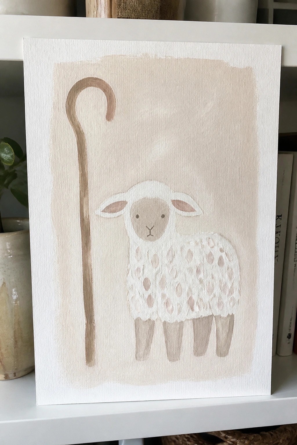 Watercolor sheep with fluffy white fleece and brown spots beside a curved staff