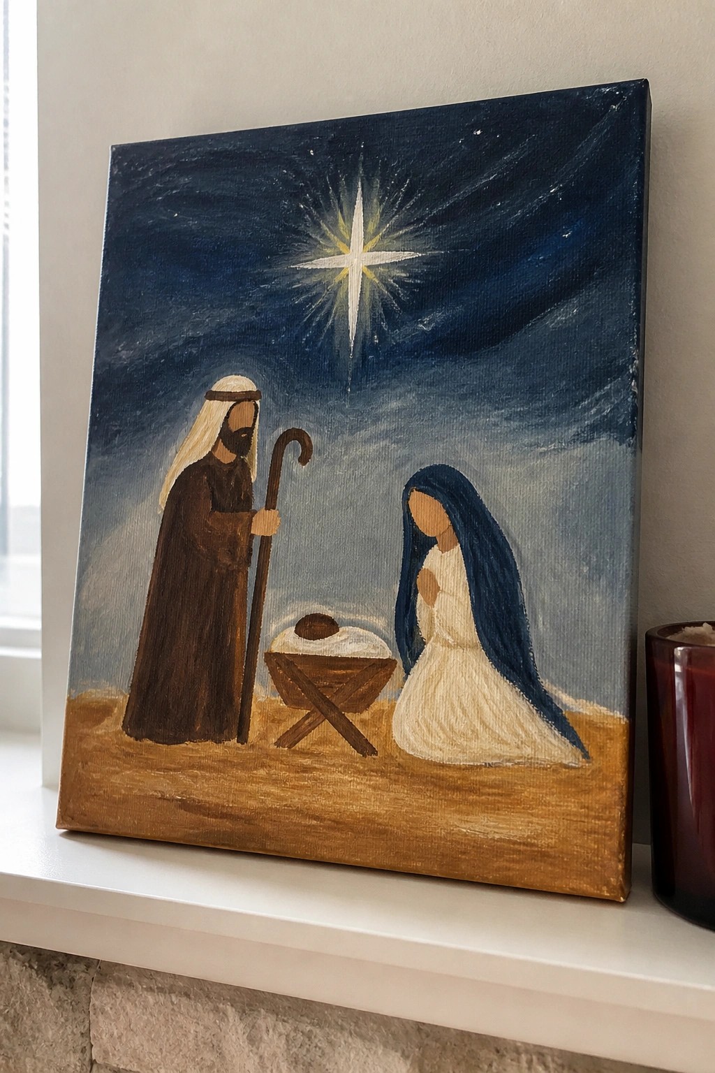 Nativity painting of Joseph in brown robe and Mary in white by manger under bright star.