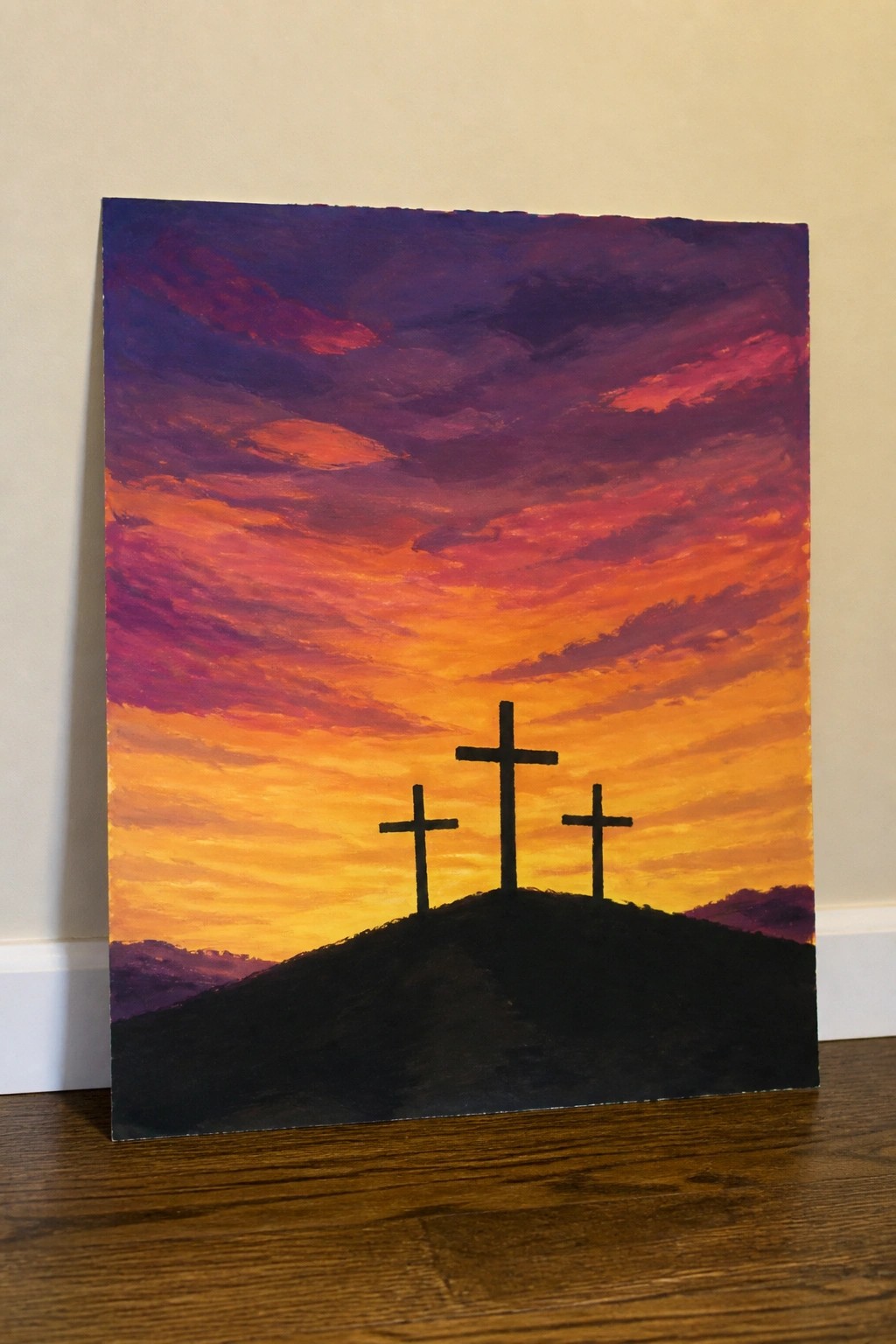 Three silhouetted crosses on a hill beneath a vivid purple-orange sunset sky