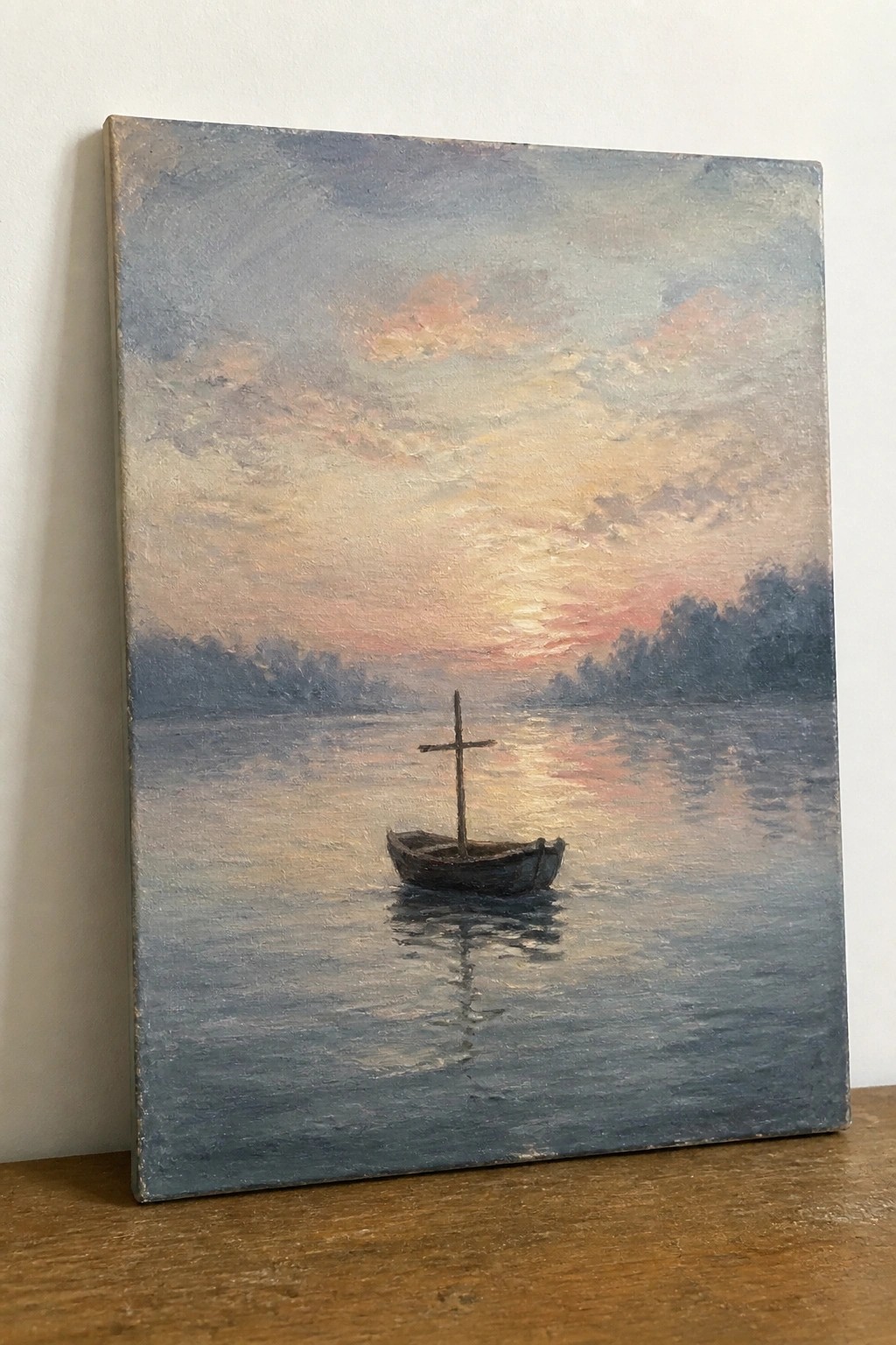 Wooden boat with cross on calm water under pink-orange sunset sky with trees