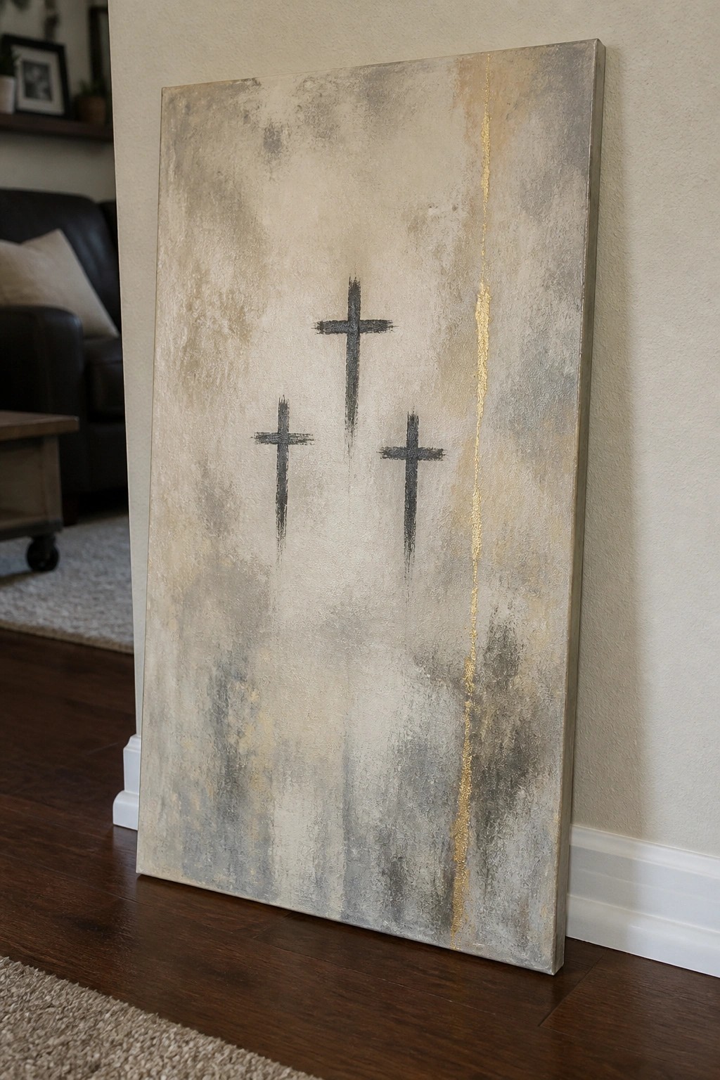 Abstract painting with three black crosses on textured beige and gold canvas