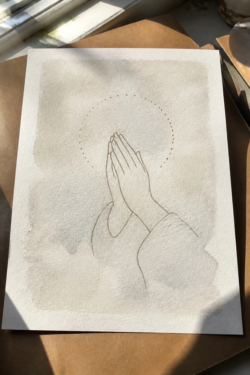 Line drawing of praying hands with dotted halo on textured paper