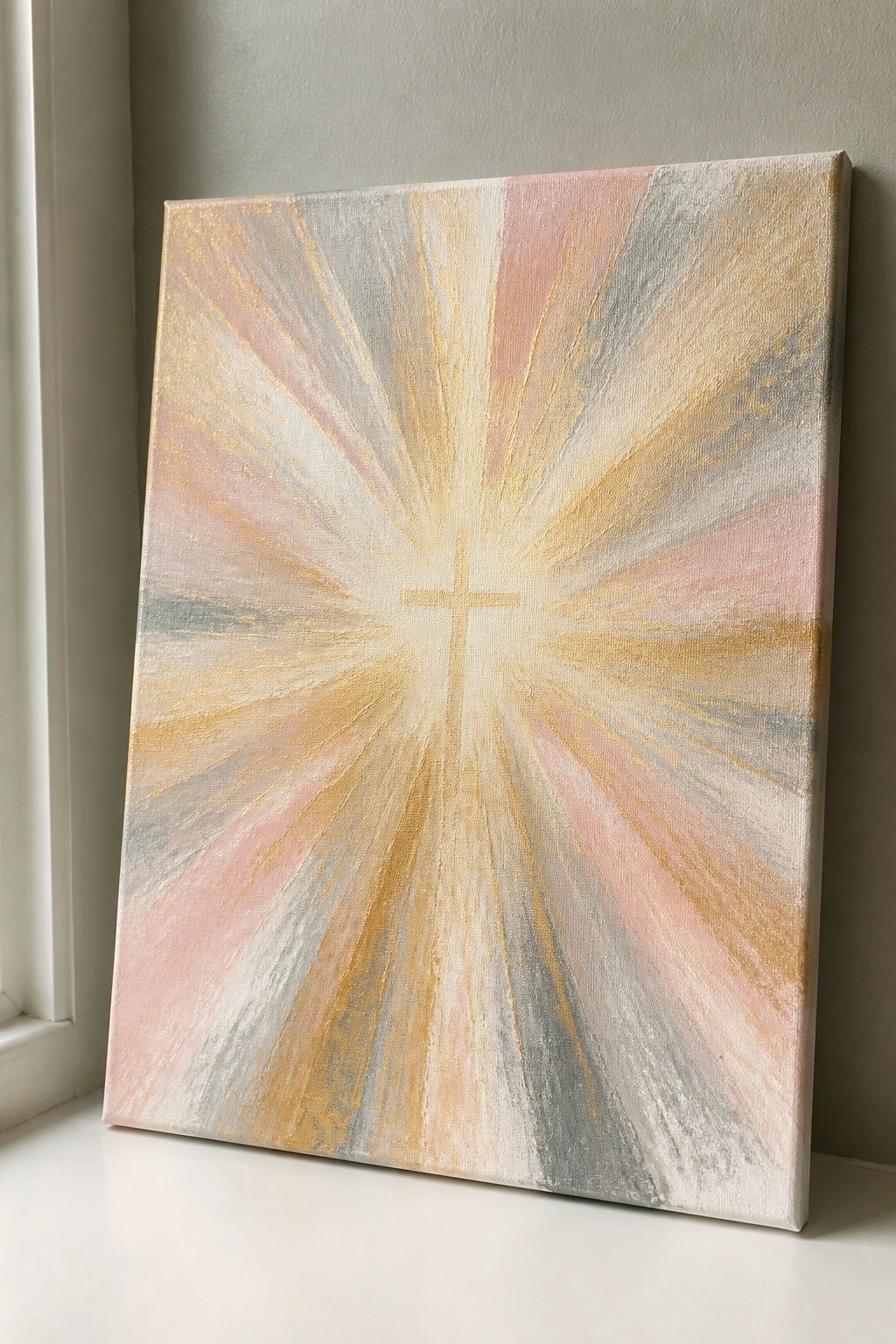 Abstract canvas painting with central cross and pink-gold radiating rays against wall.