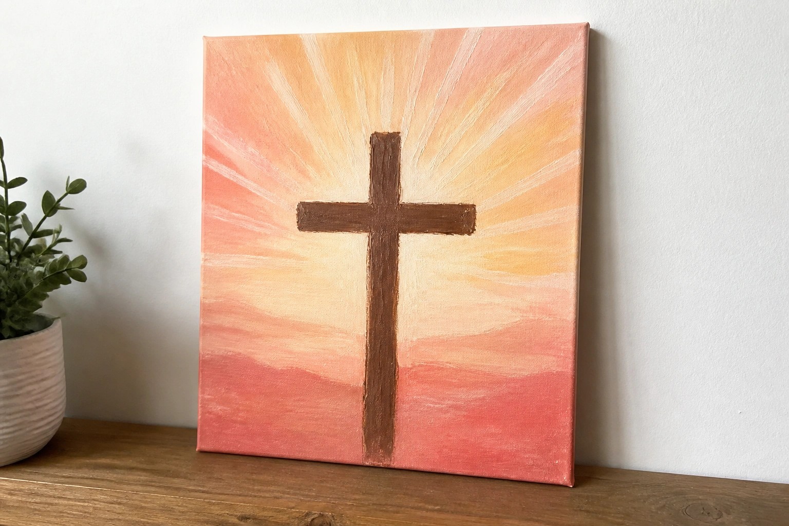 White cross with radiating rays on yellow-to-pink gradient canvas painting