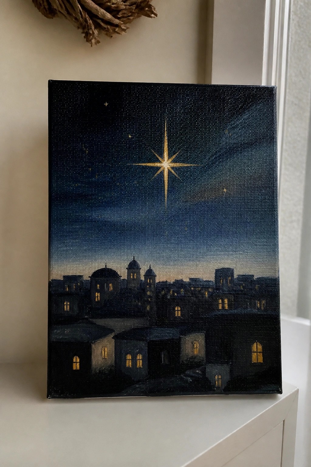 Night sky painting with a bright golden star above a city of glowing windows.