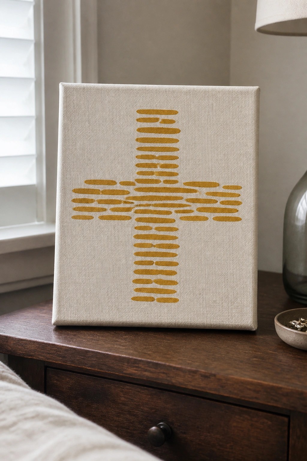Off-white canvas with golden oval-dash cross on dark wooden table