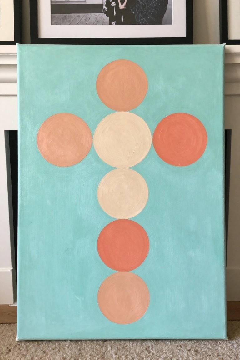 Abstract painting on teal canvas with orange and peach circles forming a cross shape.