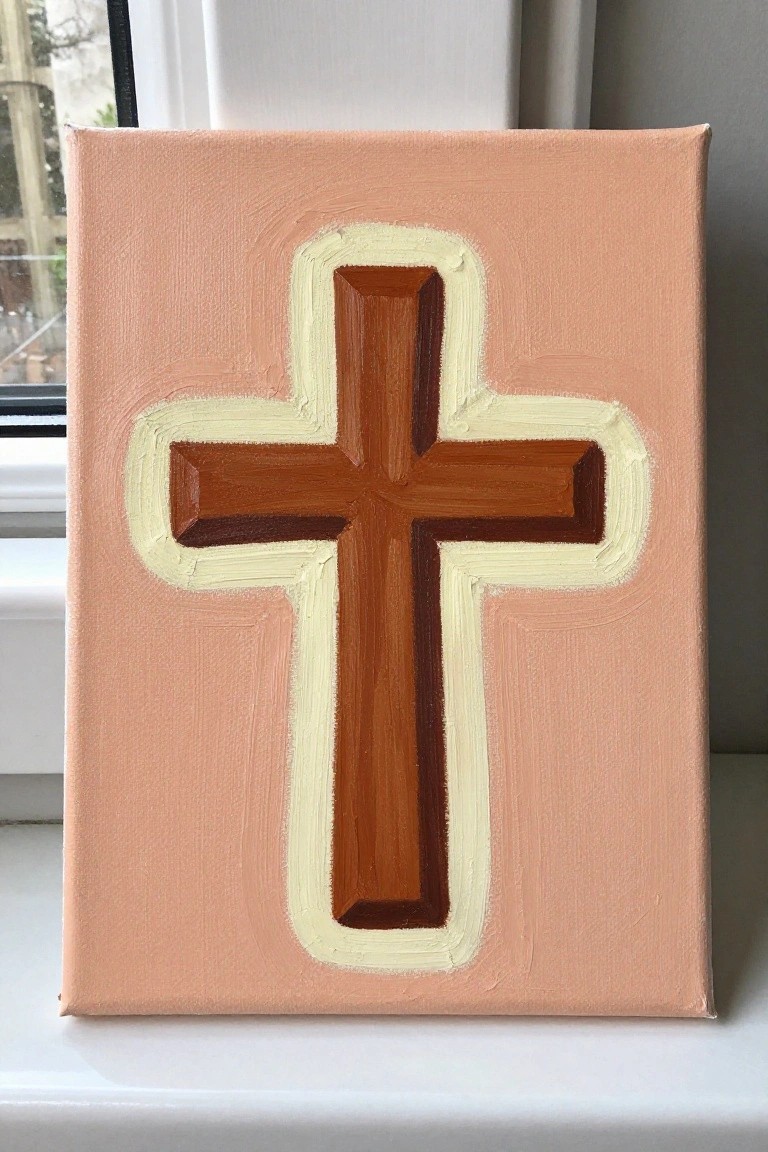 Brown cross with cream outline on peach painted canvas with brushstrokes.