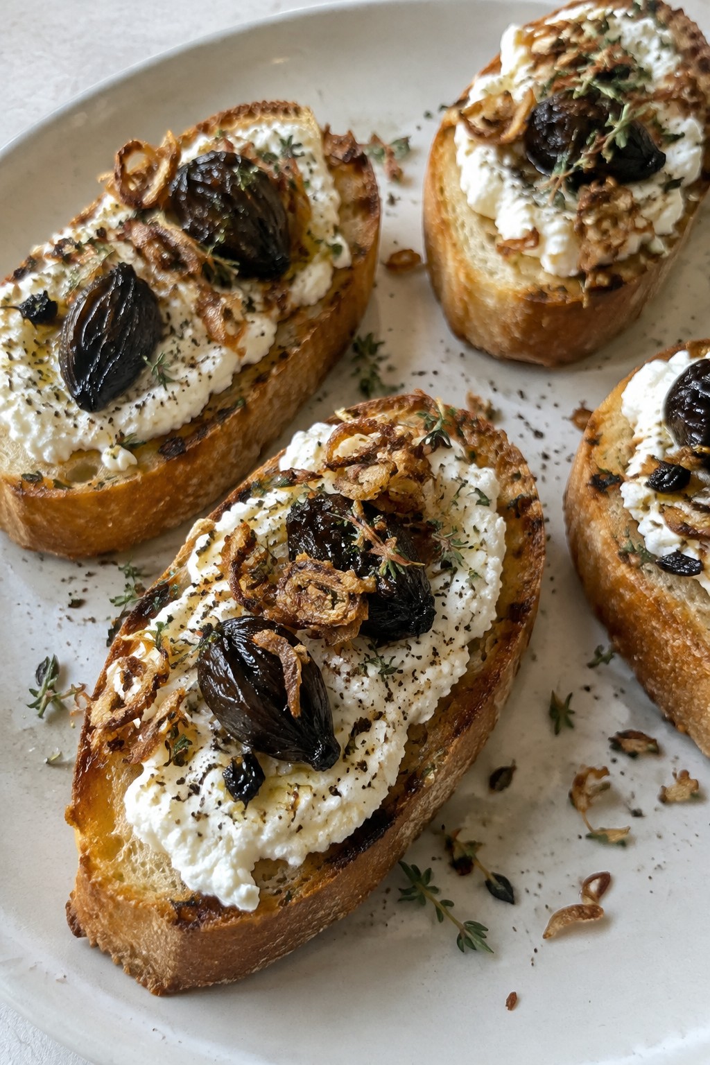 Black Garlic Crostini with Whipped Ricotta and Crispy Shallots