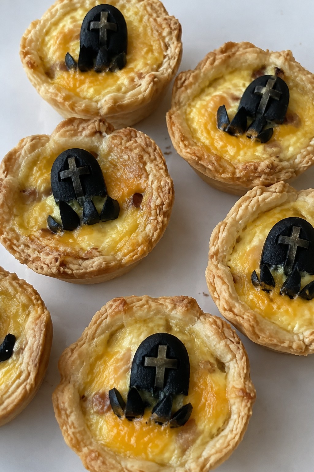 Mini Quiche Bites Topped with Olive Tombstones