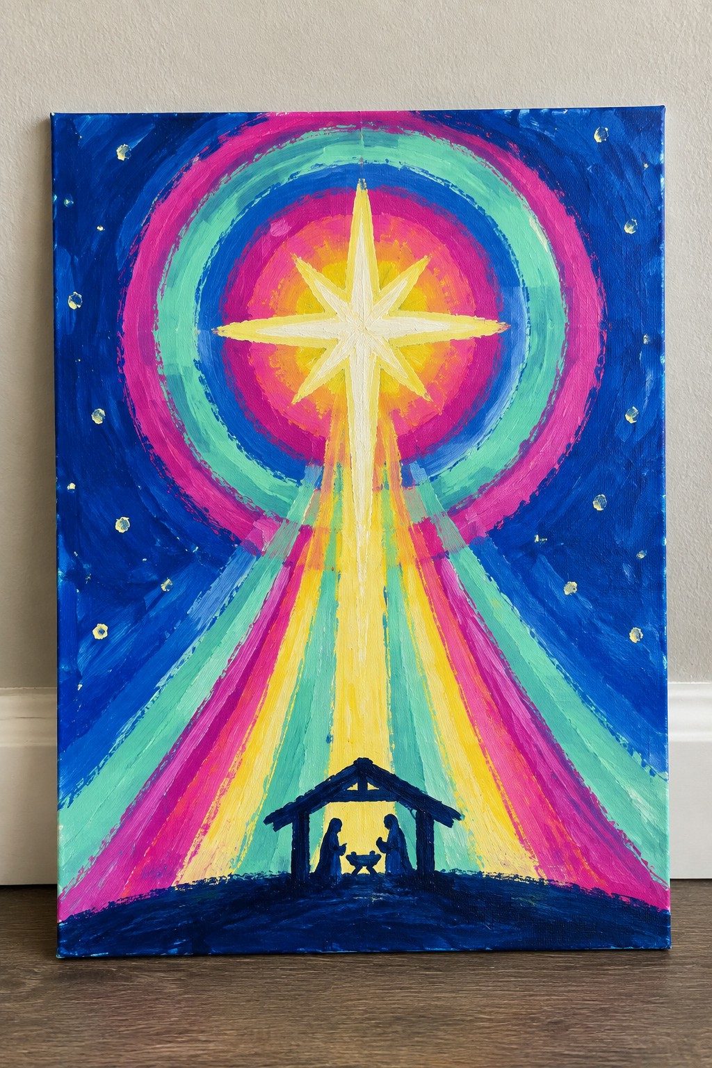 Vibrant painting of glowing star with colorful rays over silhouetted nativity stable