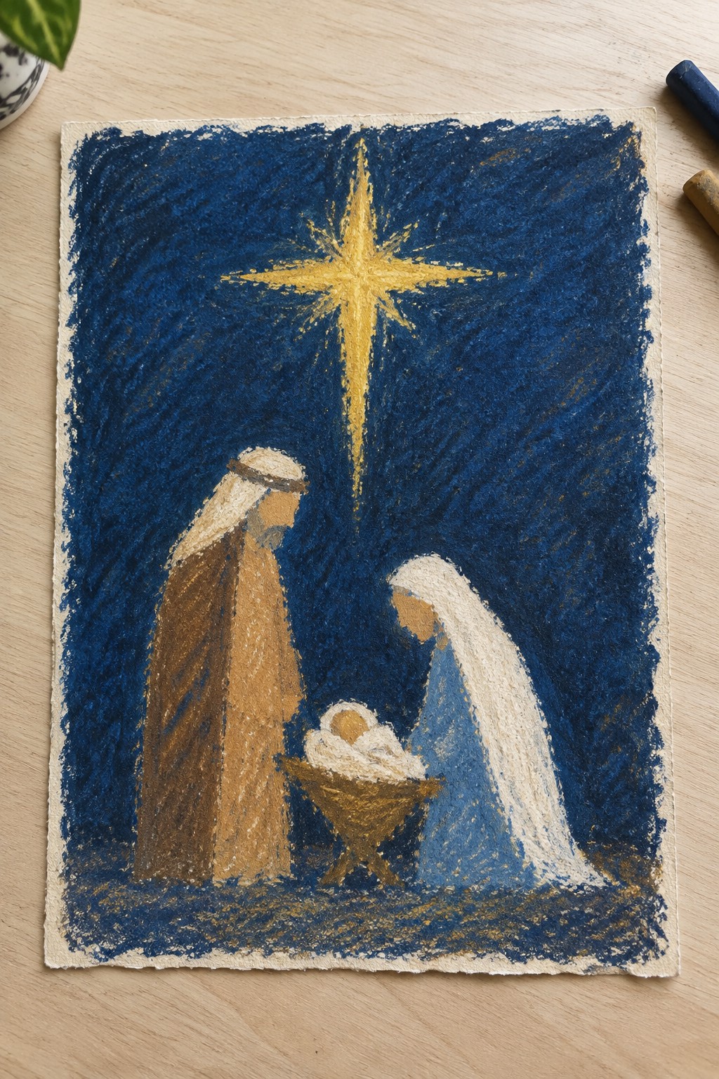 Chalk pastel nativity with brown-robed Joseph, blue-clad Mary, and golden star.